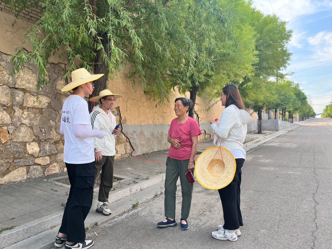 國(guó)土整治與生態(tài)修復(fù)實(shí)踐調(diào)研團(tuán)師生與村民交流。校方供圖